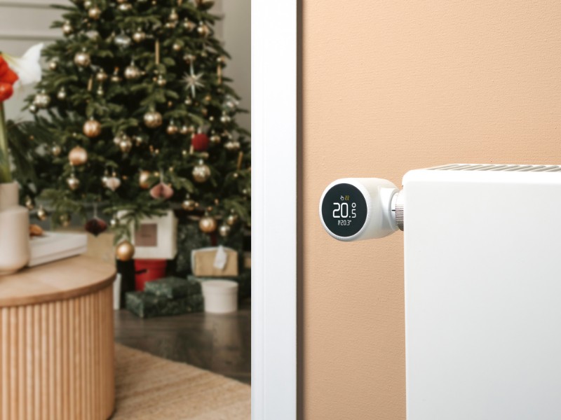 tado° Funktionen: Smartes Heizkörperthermostat X am Heizkörper, Weihnachtsbaum im Hintergrund