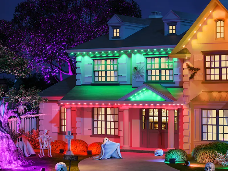 Mit bunten Outdoor-LED-Strips und Halloween-Deko verzierte Hausfassade
