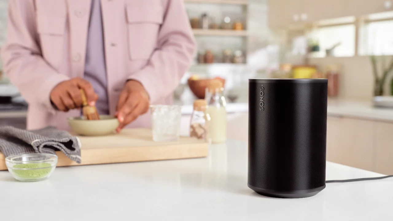 Schwarzer Sonos Lautsprecher auf einer Arbeitsplatte in einer modernen Küche beim Kochen.