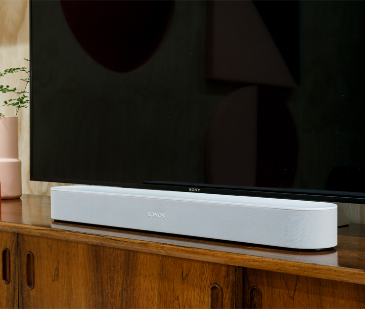 Sonos Beam smarter wlan Lautsprecher auf Holzregal vor Fernseher