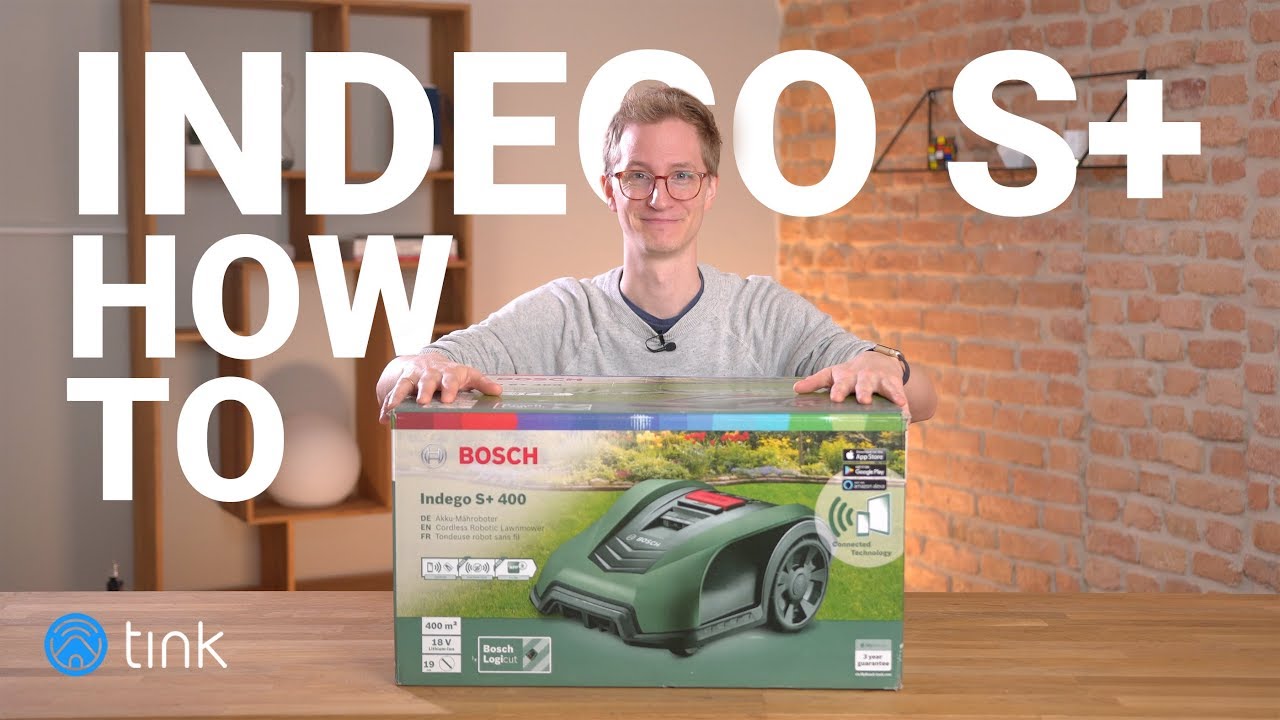 Mann mit Verpackung des Bosch Indego S+ 400