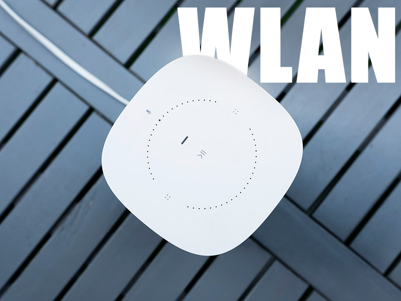 SONOS One auf Tisch mit dem Schriftzug WLAN im Hintergrund