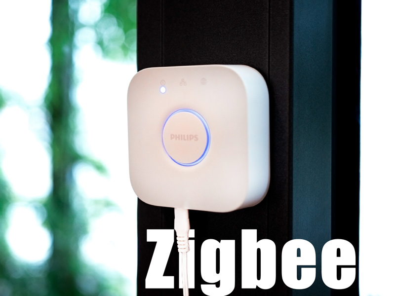 Philips Hue Bridge mit Zigbee Schriftzug im Hintergrund