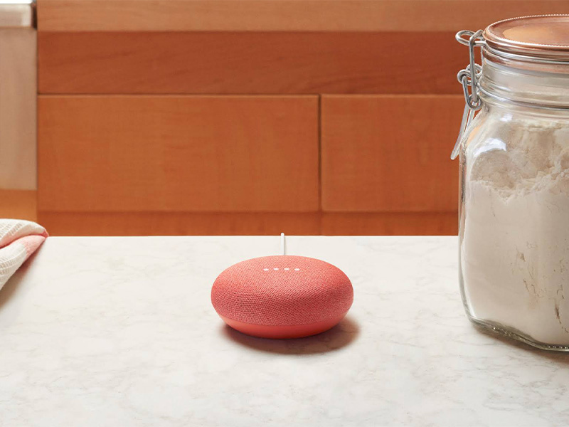 Google Home Mini in rot auf Küchentisch