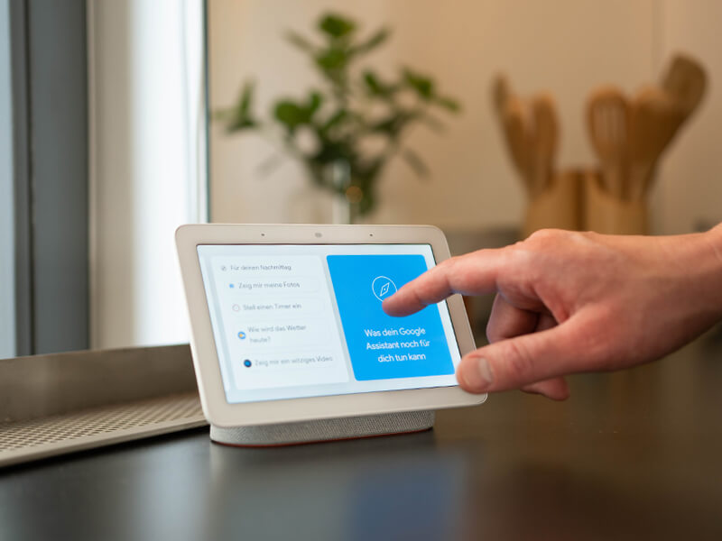 Person nutzt einen Google Nest Hub in der Küche