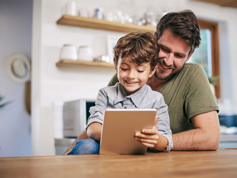 Vater mit Sohn vor einem Tablet