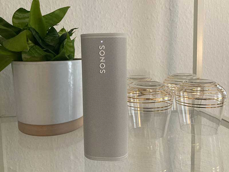 Sonos Roam stehend in Glasvitrine mit Pflanze