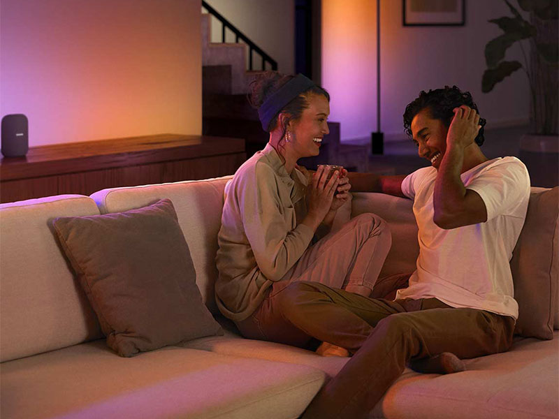 Ein Paar sitzt in einem romanischten mood , ausgestrahlt von Philips Hue
