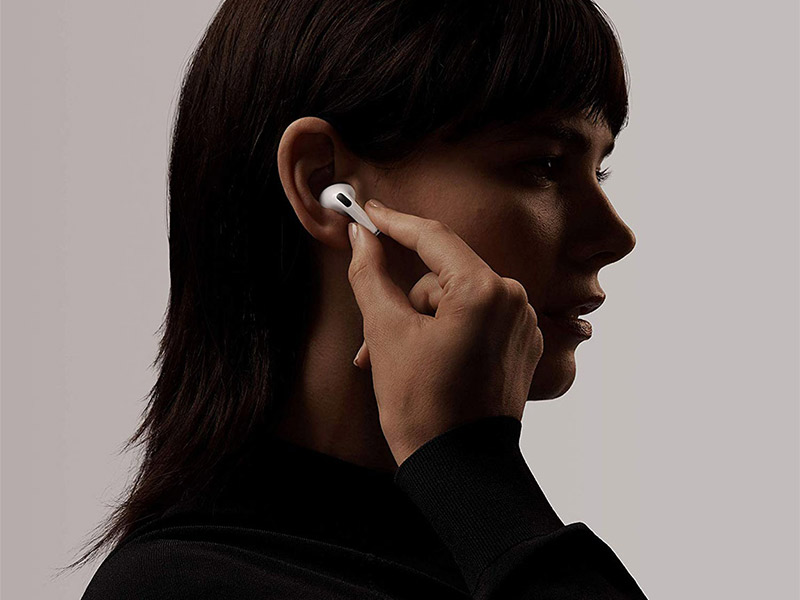 Frau steckt sich einen Apple AirPod ins Ohr.