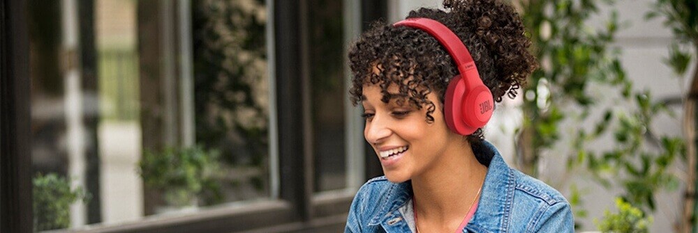 Frau mit roten JBL-Over-Ear-Kopfhörern